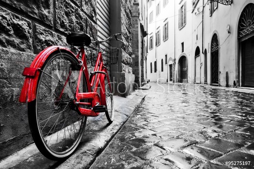 Bild på Retro vintage red bike on cobblestone street in the old town Color in black and white